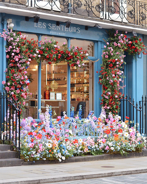 London shop front with flower doorway arch and floral spring event display