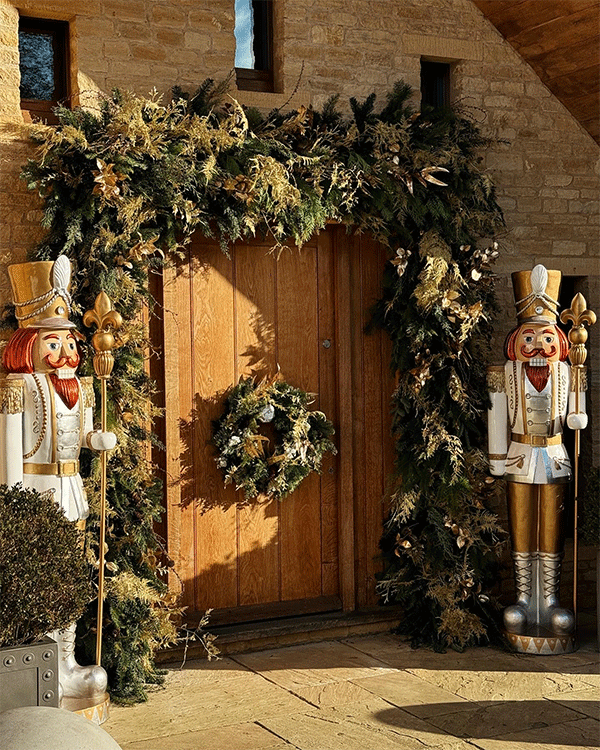 Exterior of house doorway decorated with wreaths and nutcracker installation in Surrey