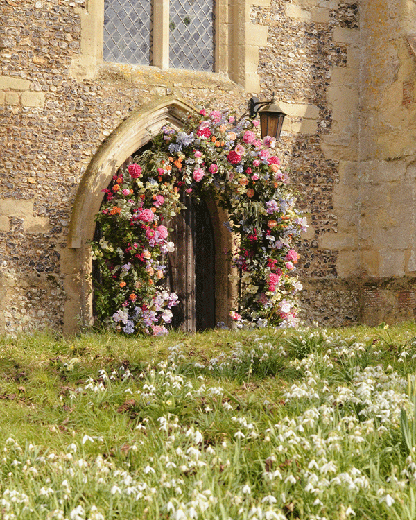 Silk floral arch for wedding outside church in Berkshire
